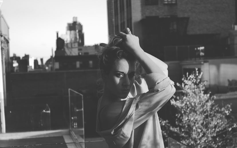 Ella Rae posing in a loose shirt while holding her hair up