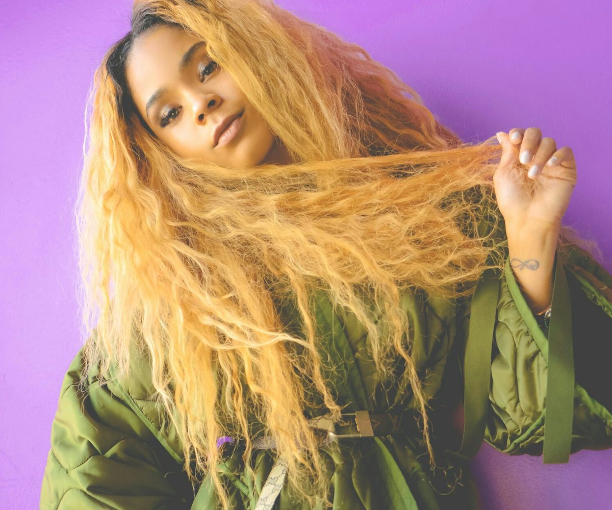 Tayla Parx posing in front of a purple background