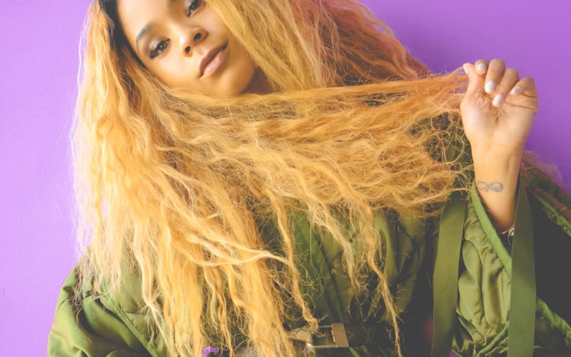 Tayla Parx posing in front of a purple background