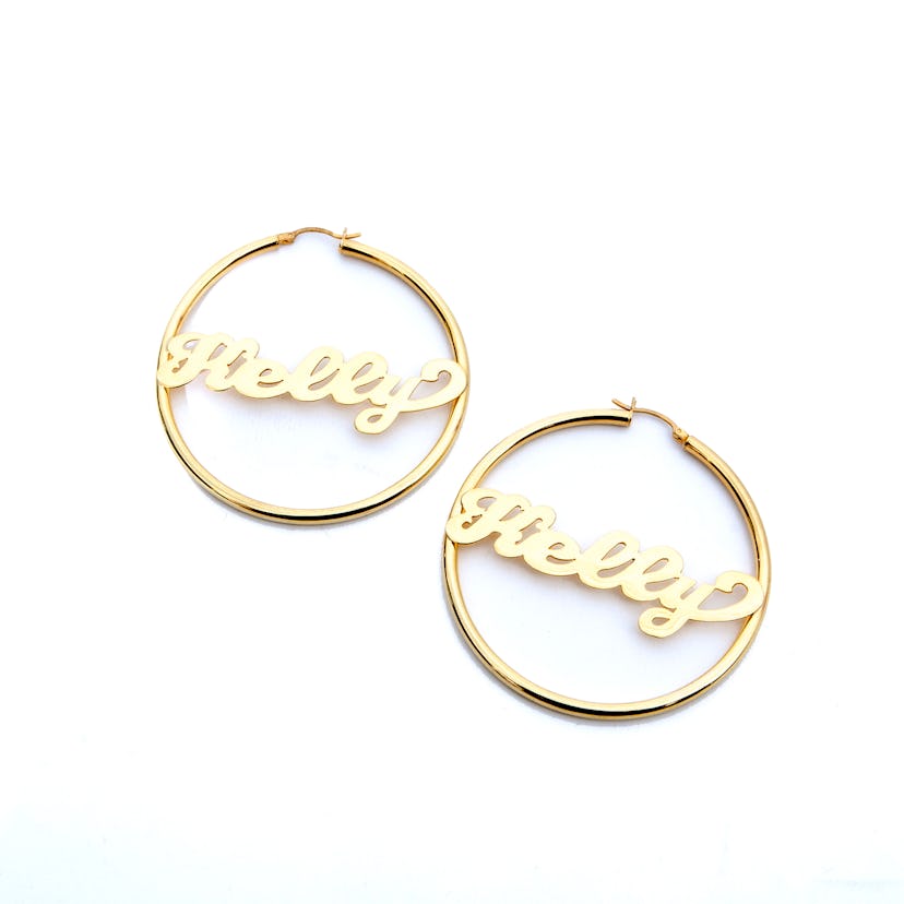 Golden name hoops with Kelly, with the center part shaped like the name Kelly, by The M Jewelers