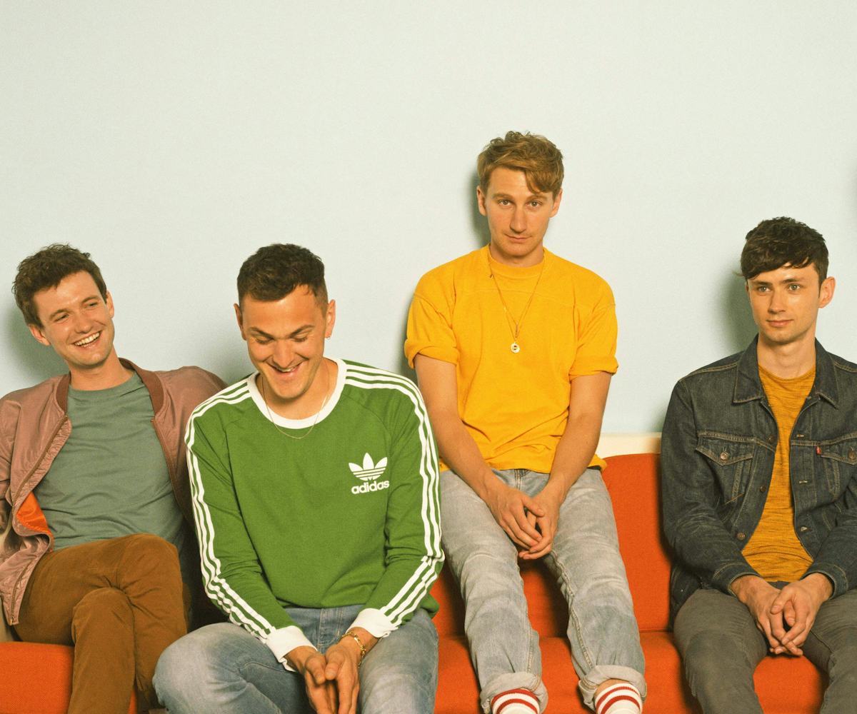 Drew Mac Farlane, Joe Seaweed, Dave Bayley, and Edmund Irwin sitting on an orange couch