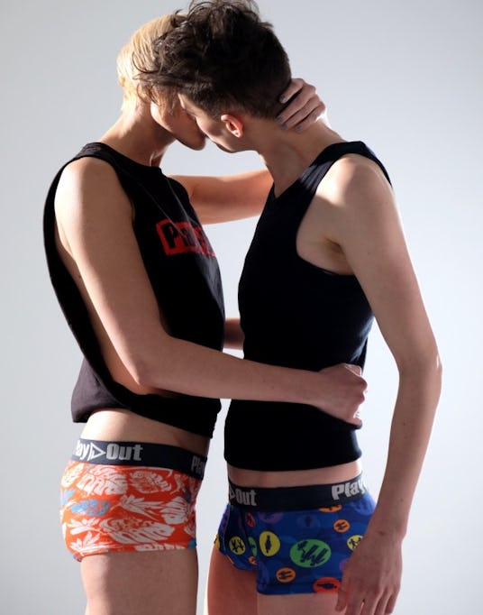 Two men wearing multicolored underwear kissing 