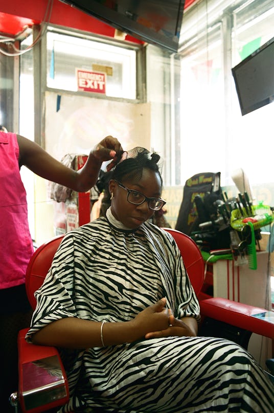 A girl in a hair salon getting an Afro-Caribbean hairstyle 