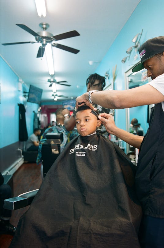 A little boy getting a haircut at a hair salon 