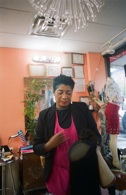 A hair stylist at a salon, holding a wig 