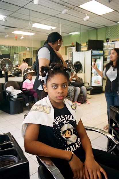 A little girl at a hair salon with clips in her hair 
