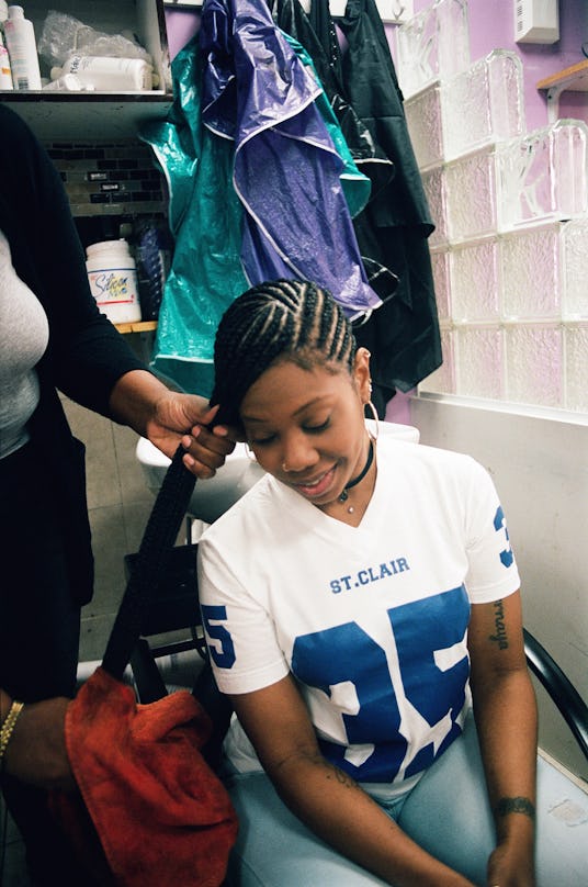 A woman getting her hair braided at a salon 