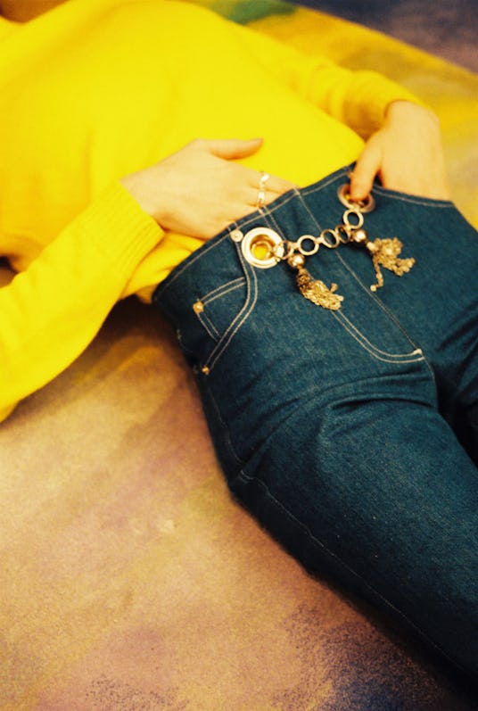 Woman wearing a yellow sweater and jeans from designer Alexia Elkaim's clothing brand Miaou 