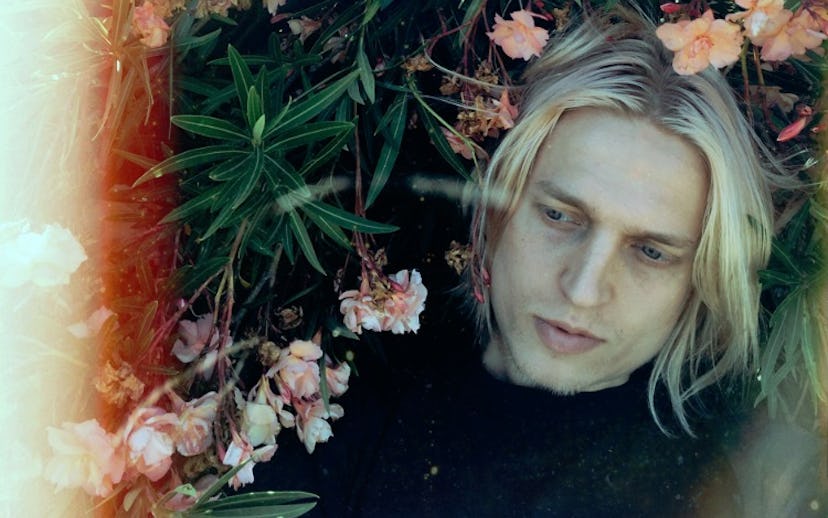 Artist Mosss posing in a field of flowers for a cover of  “Here If You Want (Pale Blue).”