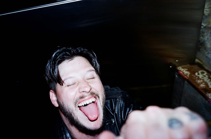 Nathan Williams of the Wavves band smiling with his tongue out and eyes closed 