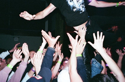 Wavves band member jumping into a crowd of fans in the attempt to crowd surf