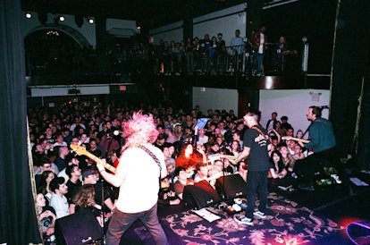 The members of the Wavves band perform on a stage in front of a crowd