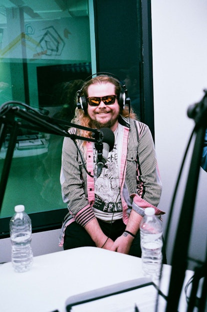 Stephen "Stevie" Pope of Wavves wearing a grey jacket with pink accents, glasses and headphones in a...