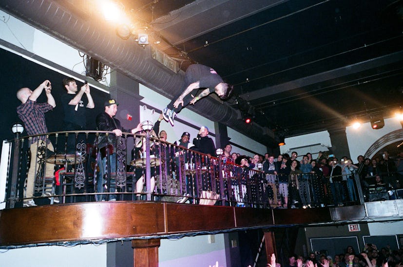 A man jumping and doing a flip into the crowd on the Wavves show
