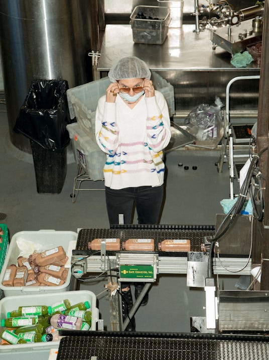 The worker called Antebi is walking the guest through the factory and shows her how juices are made