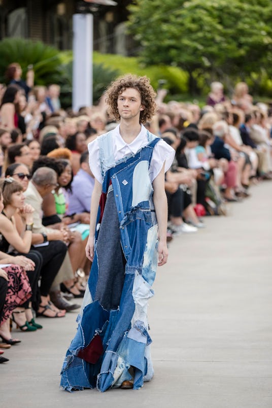 Male model going down the runway wearing a ripped denim outfit