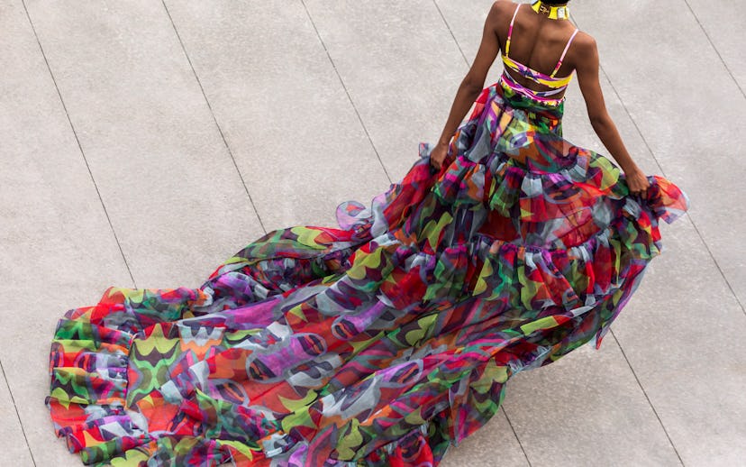 Woman with a long multicolored dress with an exposed back walking