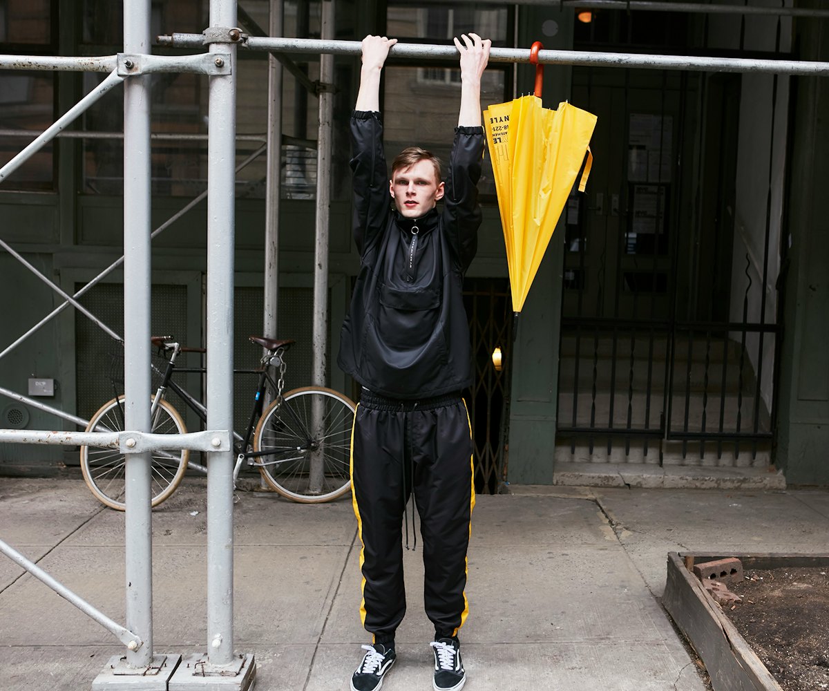 Daniel Patrick wearing an Anorak Track black and yellow pullover while doing a workout pull-up