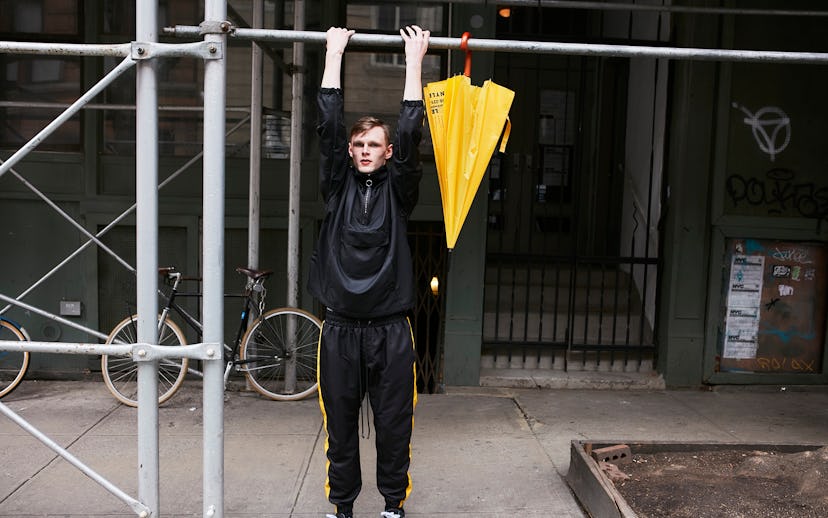 Daniel Patrick wearing an Anorak Track black and yellow pullover while doing a workout pull-up