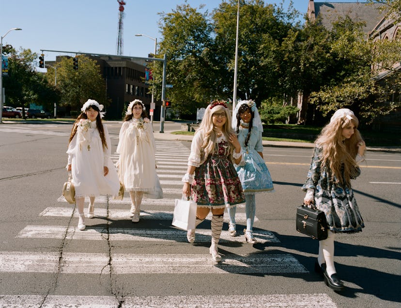 Five girls in bell shaped dressed crossing the street