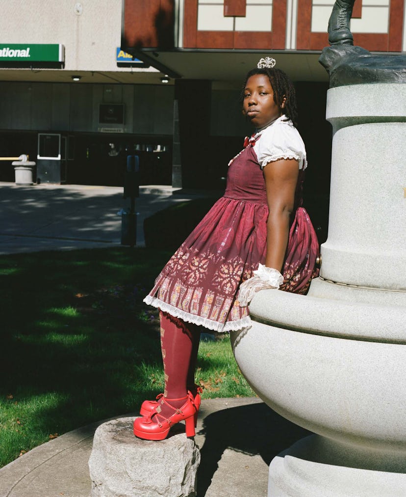 A girl posing while wearing a red bell-shaped skirt, red socks, and red heels 