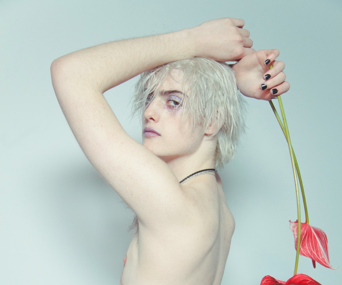 Casil McArthur, a transgender model poses with a red flower
