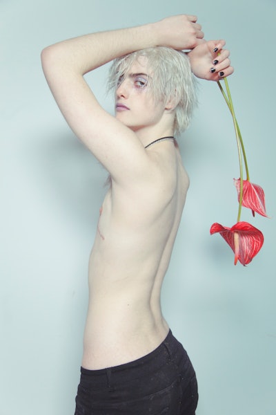 Casil McArthur, a transgender model poses with a red flower