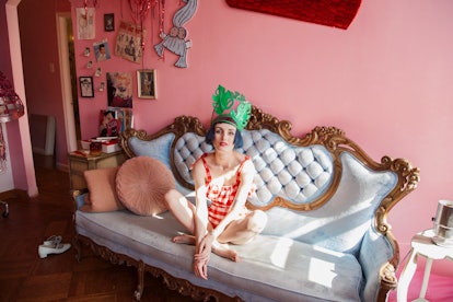 Stella Rose Saint Clair sitting on a royal baby blue couch in her pink house