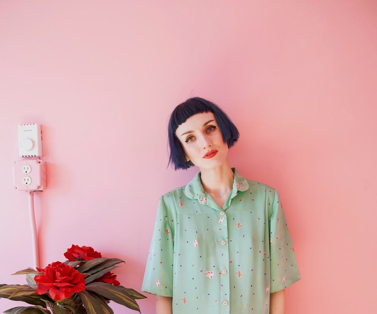 Stella Rose Saint Clair in her house in front of a pink painted wall