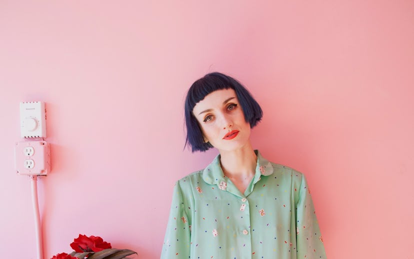 Stella Rose Saint Clair in her house in front of a pink painted wall