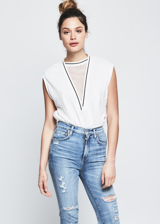 Female model wearing a white top and jeans from the RARELY collection