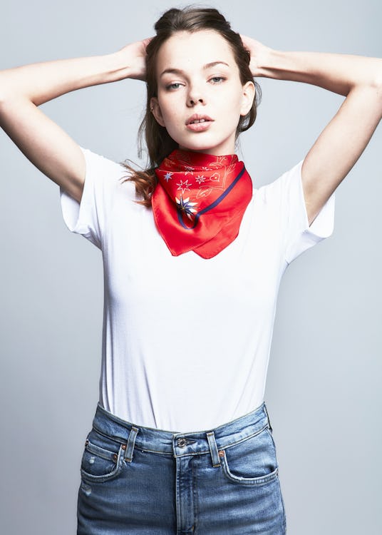 Female model wearing a white top, jeans and a red scarf from the RARELY collection