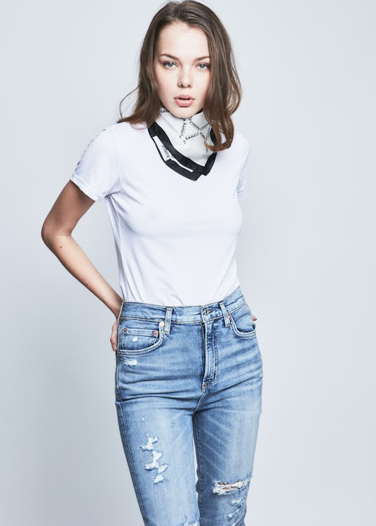 Female model wearing a white top, jeans and a racing stripe scarf from the RARELY collection