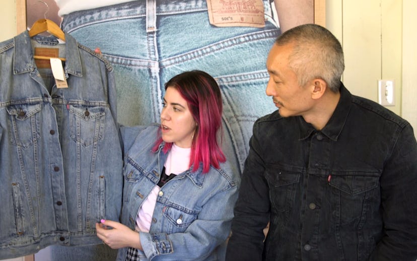 Woman with a brown/pink bob-length haircut showing a denim Levi's jacket to Jonathan Cheung who's we...
