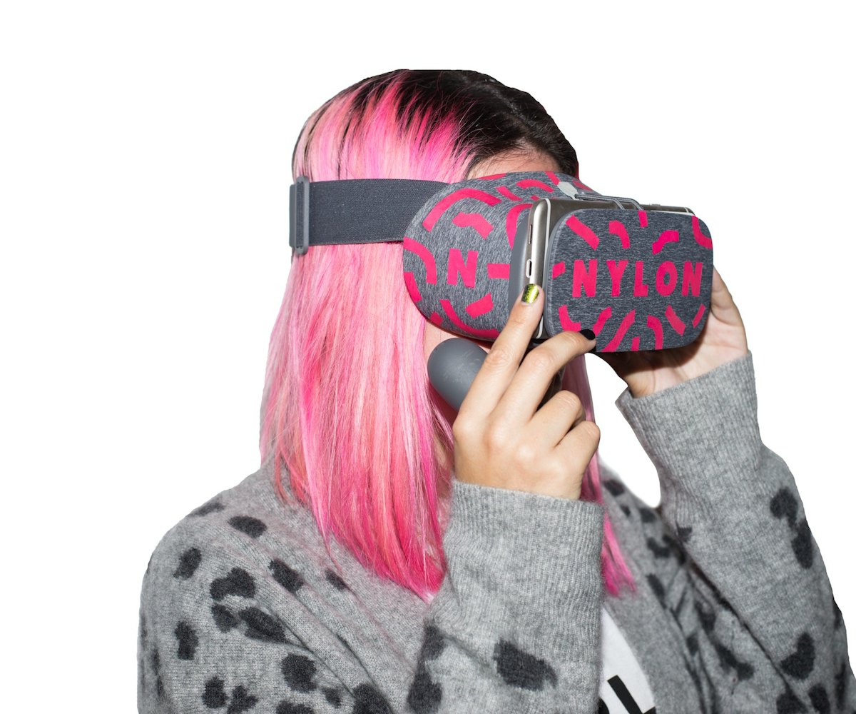 A woman with pink hair wearing a grey and black leopard pattern sweater and Nylon branded virtual re...