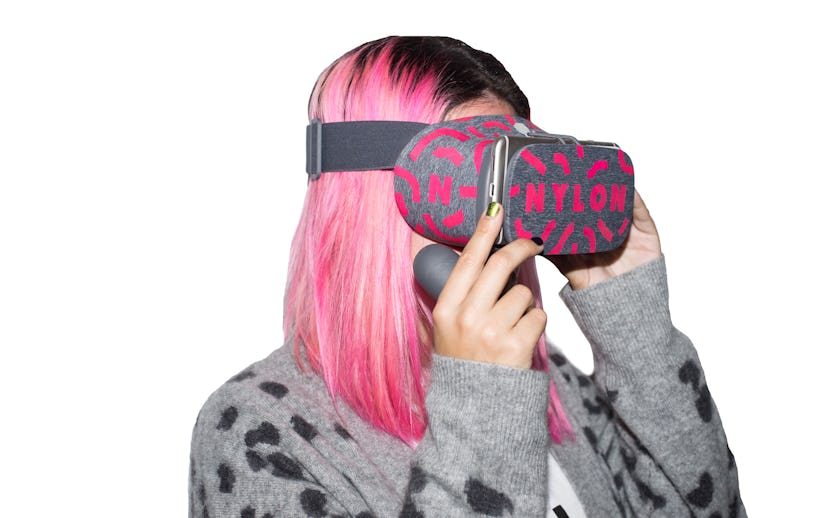 A woman with pink hair wearing a grey and black leopard pattern sweater and Nylon branded virtual re...