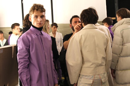 A boy posing in a purple shirt at the Berlin Fashion Week