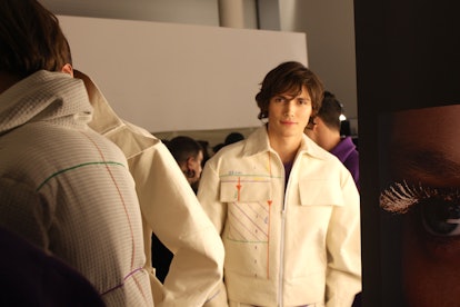 A male model posing in a white jacket at the Berlin Fashion Week