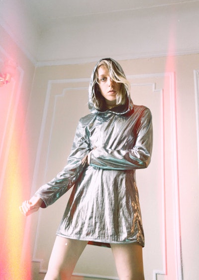 Female singer Errmine wearing a silver jacket for the cover of her debut single Driver's seat