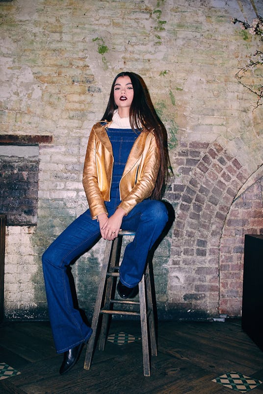 Amy sitting in a MISSY SKINS Regal Biker Style Leather Jacket in gold, Ei8ht Dreams Denim Flare Over...