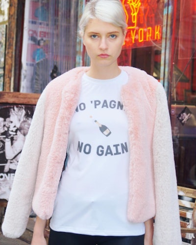 Blonde girl wearing a "No pain no gain" shirt and a pink fur jacket 