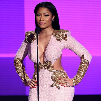 Nicki Minaj with straight hair and a black eyeliner wearing a cut out pink dress with gold details