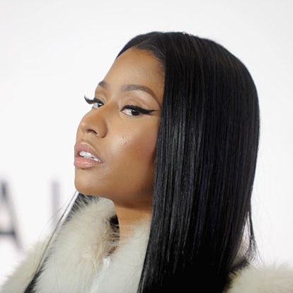 Nicki Minaj with simple makeup and eyeliner on her face posing in a fur coat