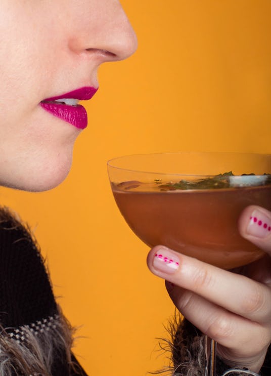 A woman holding a glass of a brown winter drink