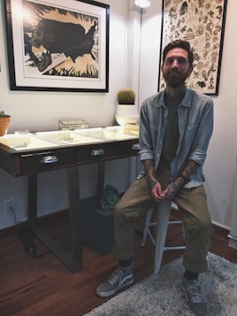 J. Colby Smith sitting in his piercing studio