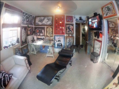 Luiz Segatto's piercing and tattoo studio, with tattoo designs on the wall and a reclining chair in ...