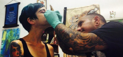 A man giving a woman a nose piercing at the Stingray Body Art studio