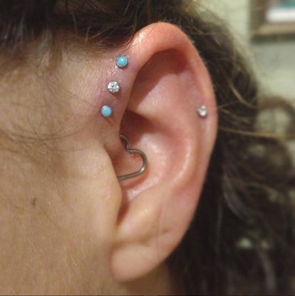 An ear with four small dot piercings