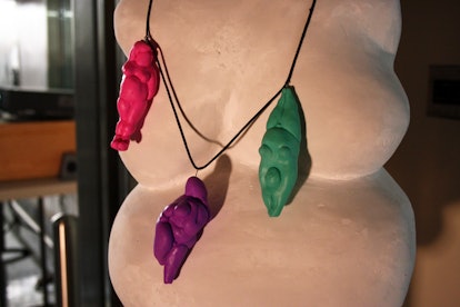 A sculpture of a naked body with pendants in the shape of naked bodies