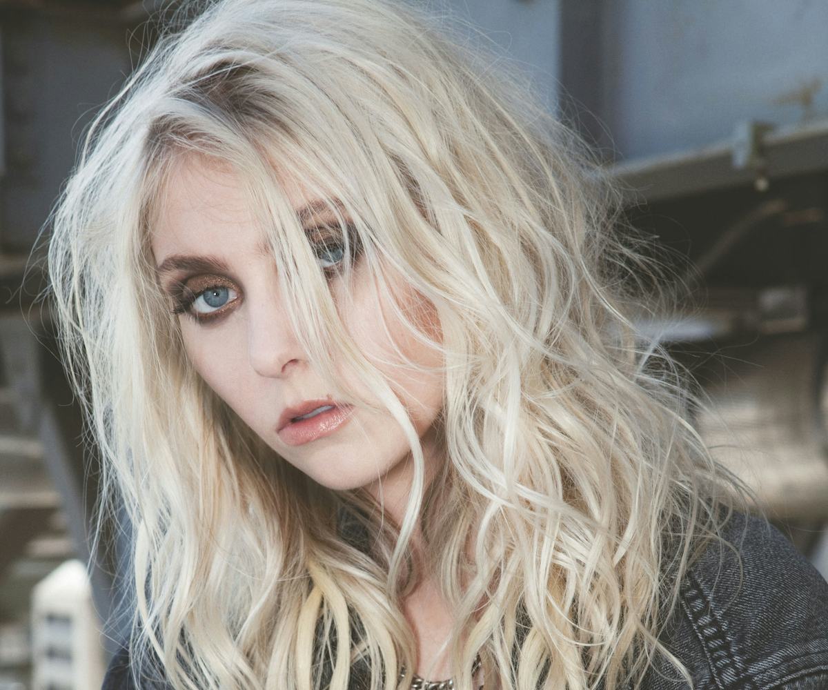 Taylor Momsen in a dark denim jacket, with messy, blond hair, and dark eye make-up, wearing jewelry ...